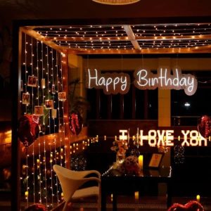Birthday surprise candle light dinner decoration with balloons, candles, romantic table setup, and warm ambient lighting