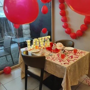 Luxury candle light dinner decoration with premium table setup, floral centerpieces, multiple candles, and elegant ambient lighting