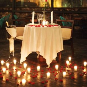 Luxury candle light dinner decoration with elegant table setup, floral arrangements, ambient lighting, and premium romantic décor