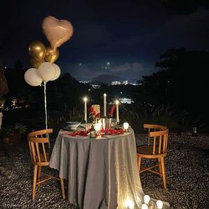 Simple candle light dinner setup at home with candles, rose petals, and elegant table decor for a romantic evening