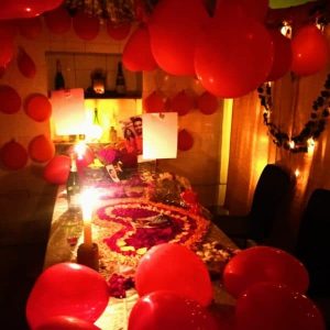 Valentine’s Day candle light dinner decoration with romantic setup, red roses, candles, heart décor, and warm ambient lighting