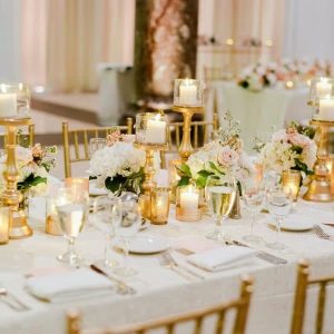 White and gold luxury candle light dinner decoration with elegant table setup, candles, floral accents, and premium ambient lighting