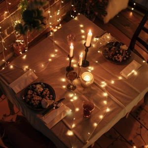 Fairy lights and candle combo setup for a romantic dinner at home with warm lighting, elegant table décor, and cozy ambiance