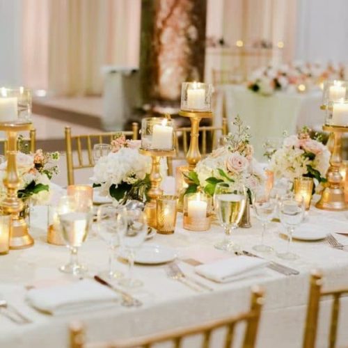 White and gold luxury candle light dinner decoration with elegant table setup, candles, floral accents, and premium ambient lighting